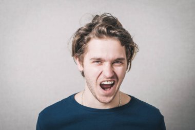 Adam somurtuyor. Gri arkaplan