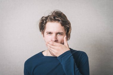 Bir adam esniyor. Gri arkaplan