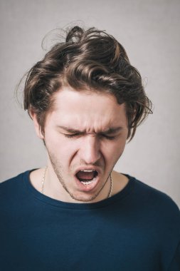 Adam bağırıyor, umutsuzluk, keder. Gri arkaplan