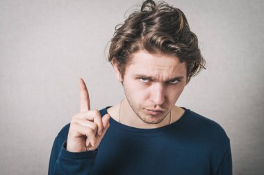 İşaret parmağı gösteren bir adam. Gri arkaplan