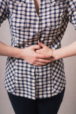 Karın ağrısı çeken bir iş kadını görüntüsü.