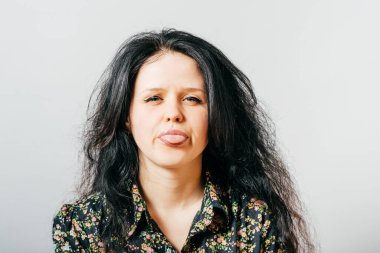 Stüdyo arka planında dil gösteren kız