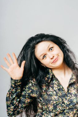 Bir kadın elini gösteriyor, merhaba.