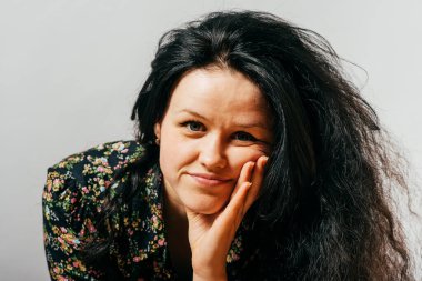 Kız çenesini eline koydu.