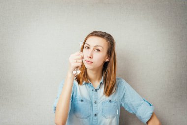 Kadın anahtarı elinde tutuyordu. Gri arkaplanda izole