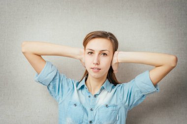 Jest yapan kadın elleriyle kulaklarını kapatıyor. Gri arkaplanda izole