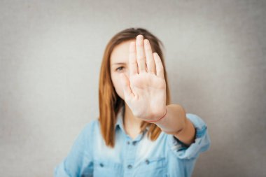 Kötü davranışları olan, el hareketleriyle el hareketi yapan, beyaz arka planda izole edilmiş genç, rahatsız bir kadının yakın plan portresi. Negatif insani duygu, yüz ifadesi hissi, vücut dili