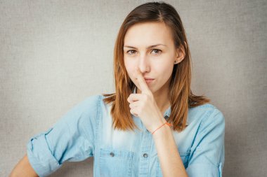 Kız parmağını dudaklarına koydu.