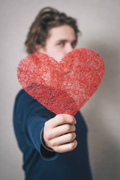 Kırmızı Kalpli Bir Adam Gri Arkaplan — Stok fotoğraf