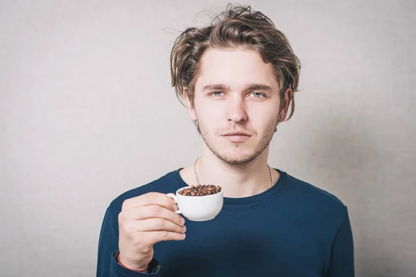男人与一杯咖啡豆 灰色背景 — 图库照片