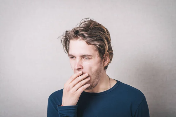 男があくびをする 灰色の背景 — ストック写真