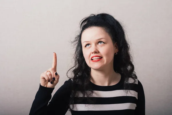 Kvinna Visar Ett Finger Upp Idén Grå Bakgrund — Stockfoto