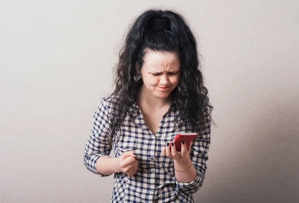 Uma Mulher Ler Uma Mensagem Triste Telefone Fundo Cinza — Fotografia de Stock