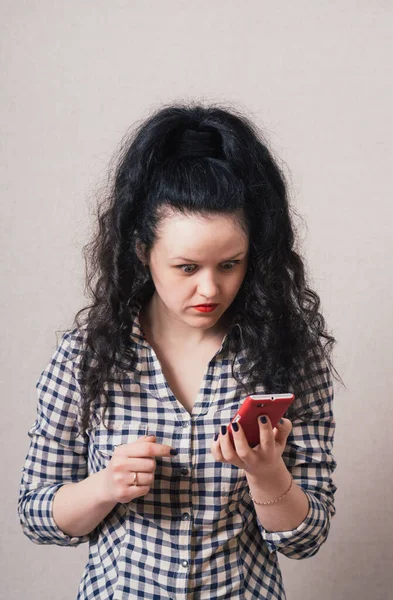 Женщина Читает Грустные Сообщения Телефону Сером Фоне — стоковое фото