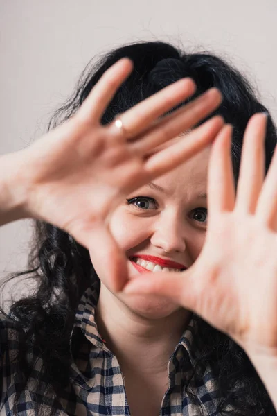 Menina Encaracolado Olhando Através Moldura Dos Dedos Fundo Cinzento — Fotografia de Stock