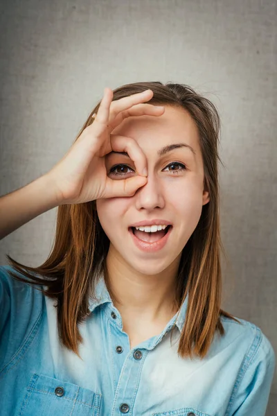 Mujer Joven Mirando Través Los Dedos Gafas Bien Sobre Fondo — Foto de Stock