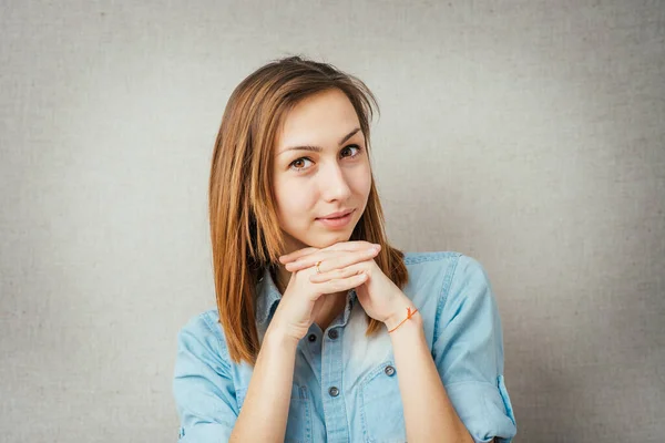 听着的女人看着摄像机 手靠在脸上 在灰色背景下隔离 — 图库照片