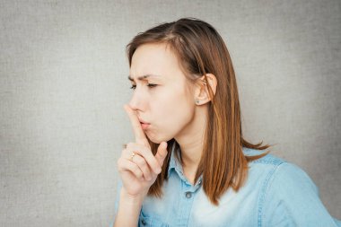 Kız parmağını dudaklarına koydu.