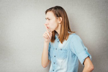 Kız parmağını dudaklarına koydu.