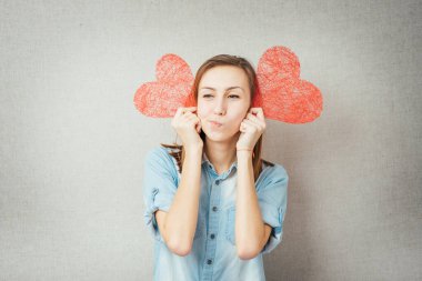 İki kağıt kalp tutan kız.