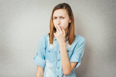 Kız, düşün ve parmağını dudaklarına koy.