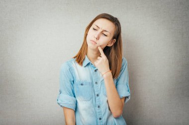 Kız, düşün ve parmağını dudaklarına koy.