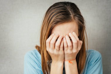Genç bir kadın elleriyle yüzünü kapattı ve ağladı.