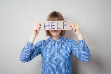 Stresli iş kadını yardım için yalvarıyor, elinde bir karton ile yardım