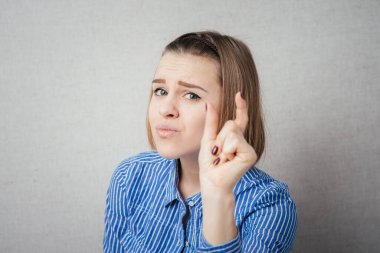 Kız görünmez bir şey gösteriyor.