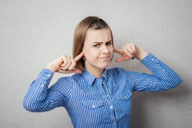 Kız kulaklarını kapatıyor.