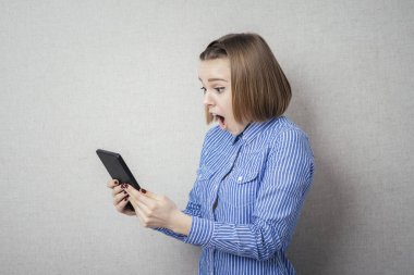 Elinde tabletle genç bir kadın şaşırdı.