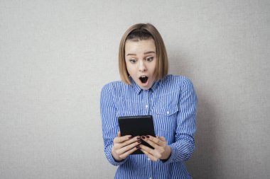 Elinde tabletle genç bir kadın şaşırdı.