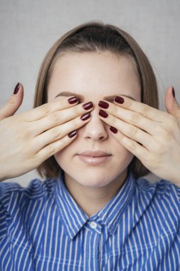 Genç kız elleriyle gözlerini kapatıyor.