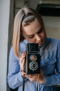 Elinde fotoğraf makinesi olan güzel ve çekici bir kadının portresi.