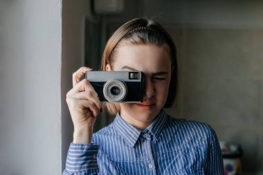 Elinde fotoğraf makinesi olan güzel ve çekici bir kadının portresi.