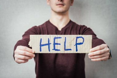 Yazı yardımı ile bir mukavva tutan adam