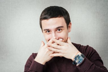 Adam gülmemek için elleriyle ağzını kapatıyor.