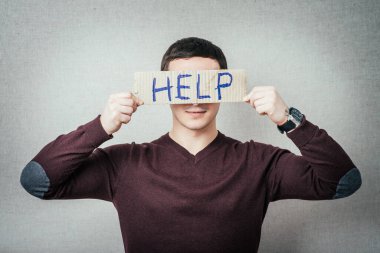 Yazı yardımı ile bir mukavva tutan adam