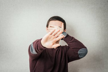 Adam durur ve yüzünü eliyle kapatır.