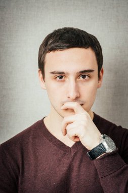 Düşünen genç adamın portresi, eli yüzüne yakın yukarı bakar.