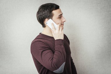 Genç adam cep telefonuyla konuşuyor.