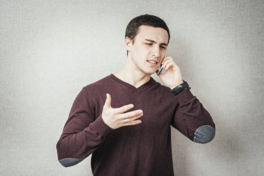 Genç adam cep telefonuyla konuşuyor.