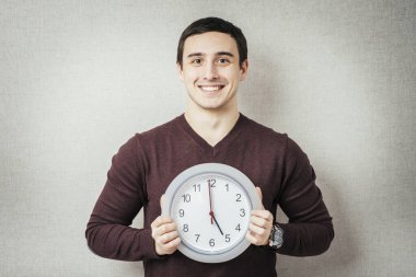 Gri Arkaplanda Saat Tutan Genç Bir Adamın Portresi