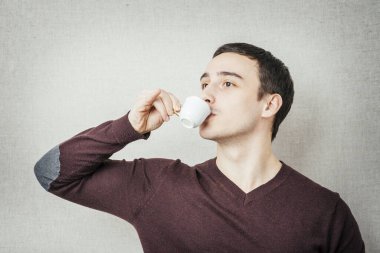 Genç adam espresso içiyor.