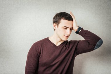 Depresyondaki genç iş adamı başını tutuyor.