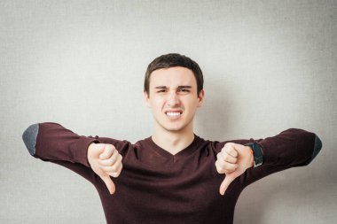 Genç üzgün adam baş parmağını kaldırıyor..