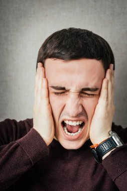 Depresyondaki genç iş adamı başını tutuyor.