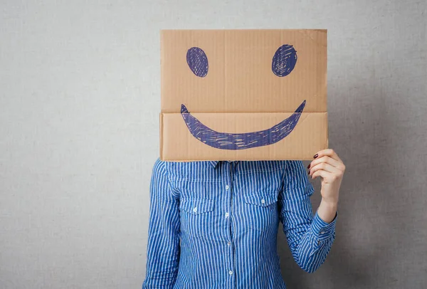 Mujer Joven Sosteniendo Cartón Con Una Cara Sonriente Delante Cabeza — Foto de Stock