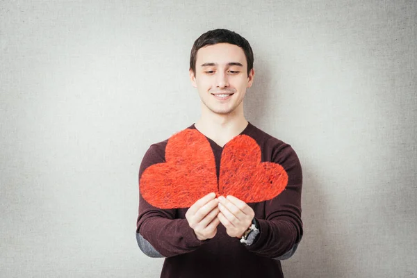 Giovane Uomo Che Tiene Tra Mani Due Cuori Rossi — Foto Stock