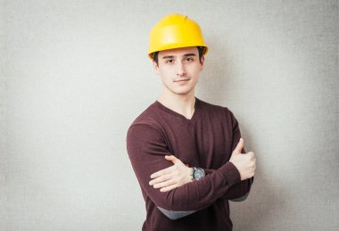 Başında ve kollarında koruyucu miğfer olan yakışıklı bir genç.